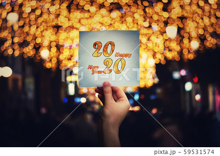 Hand holds a paper sheet with 2020 happy new year Hand holds a paper sheet with 2020 happy new year 59531574