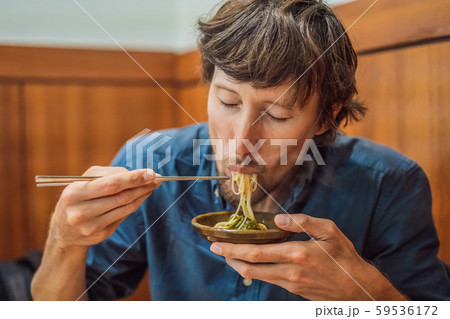Male tourist eating Korean noodles in a Korean cafe. Travel Korea Concept 59536172
