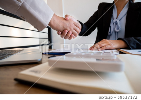 shaking hand, A team of business executives are planning consultations about business investments related to shares. By analyzing and calculating the stock market to find marketing profits shaking hand, A team of business executives are planning consultations about business investments related to shares. By analyzing and calculating the stock market to find marketing profits 59537172