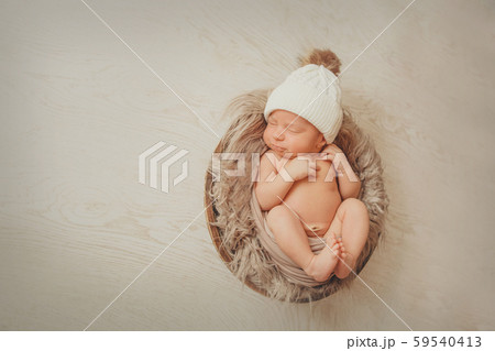a newborn baby wrapped in a blanket with a warm hat on his head. the concept of childhood, health, IVF. a newborn baby wrapped in a blanket with a warm hat on his head. the concept of childhood, health, IVF. 59540413