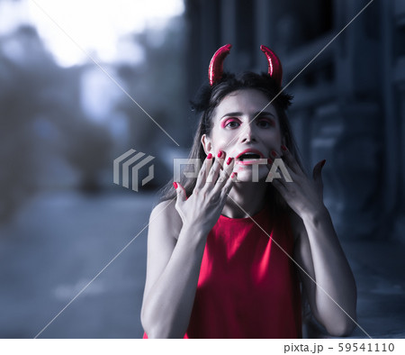 Beautiful woman in red dress and horns. Halloween 59541110