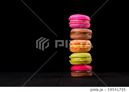 Stack of french colorful macaroons on wooden table isolated on black background Stack of french colorful macaroons on wooden table isolated on black background 59541795