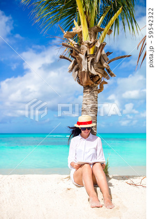 Young woman reading book during tropical white beach Young woman reading book during tropical white beach 59542322