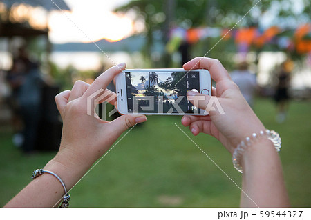 Female hand lifts the sunset on the telephone 59544327