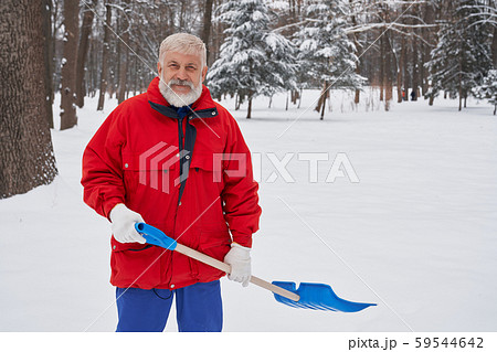 Man cleaning snow with chovel in park. Man cleaning snow with chovel in park. 59544642