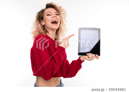 Caucasian girl with curly fair hair holds a tablet and smiles, portrait isolated on white background Caucasian girl with curly fair hair holds a tablet and smiles, portrait isolated on white background 59544981
