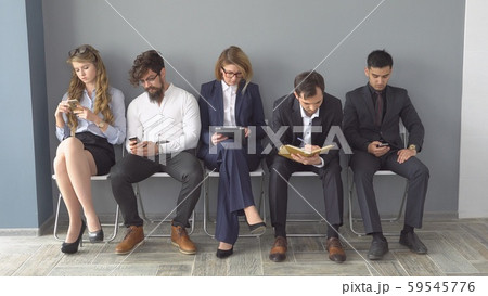Unemployed expect interviews sitting on chairs in the hallway of an office building. Unemployed expect interviews sitting on chairs in the hallway of an office building. 59545776