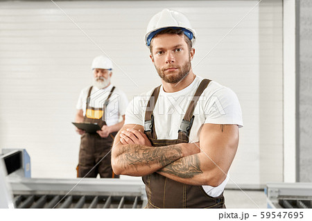 Young man in uniform and helmet on metal factory 59547695