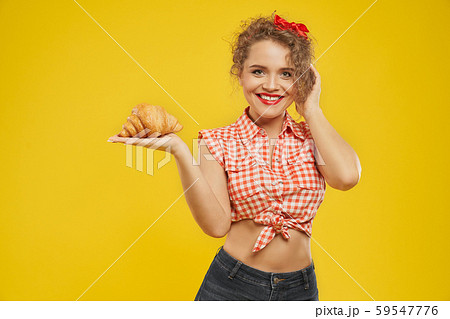 Smiling pretty woman with red lips holding fresh croissant 59547776