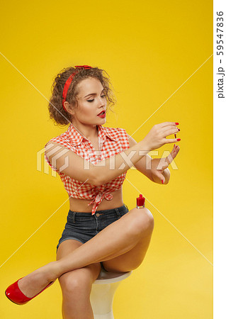 Pretty lovely blonde female applying red polish on nails Pretty lovely blonde female applying red polish on nails 59547836