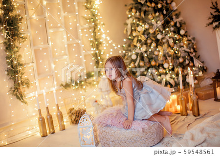 Little girl on the background of the fireplace and New Year tree Little girl on the background of the fireplace and New Year tree 59548561
