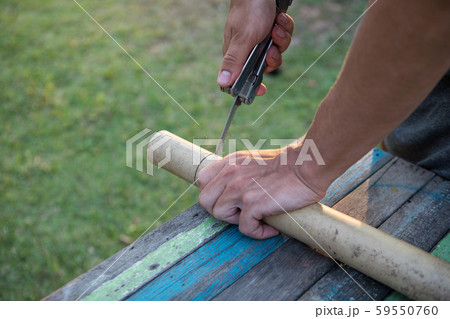 Men's hands sawing bamboo saw 59550760