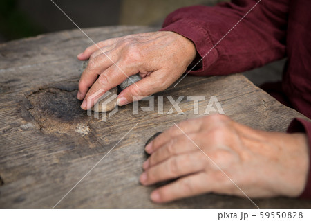 The old woman's hands are guessing on the stone The old woman's hands are guessing on the stone 59550828