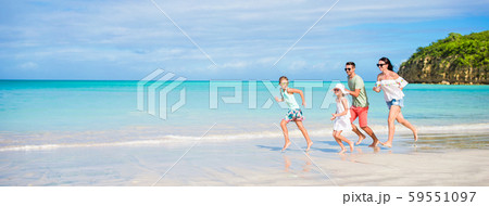 Beautiful happy family running on the seashore Beautiful happy family running on the seashore 59551097