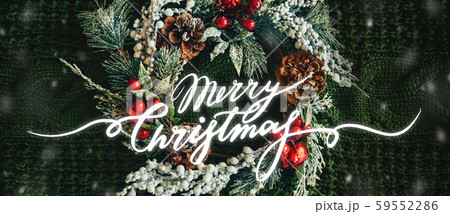 Pine wreath and Christmas decor on a green knitted. Lettering Merry Christmas Pine wreath and Christmas decor on a green knitted. Lettering Merry Christmas 59552286