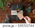 ナチュラルデザインの包装　クリスマスギフトラッピングと赤いマニキュアの女性の手 59553744