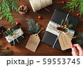 ナチュラルデザインの包装　クリスマスギフトラッピングと赤いマニキュアの女性の手 59553745