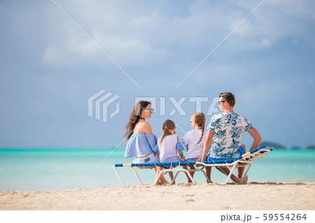 Young family on vacation. Parents and kids on sunbed enjoy the sea view 59554264