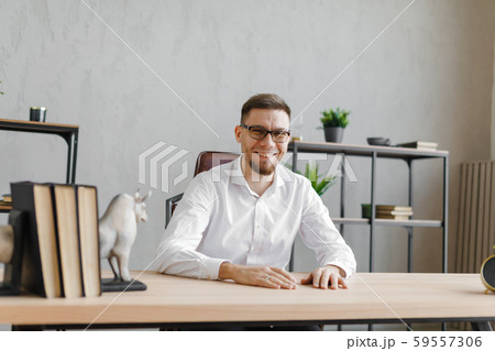 Best work. Attractive exuberant man sitting at the table Best work. Attractive exuberant man sitting at the table 59557306