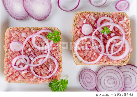 german sandwich mettbrotchen, bun and raw meat with onion and parsley, closeup 59558442