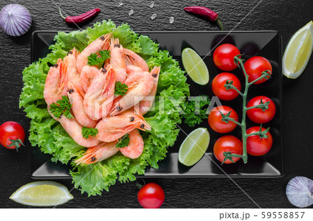 tasty cooked shrimps with tomato and lime on black background tasty cooked shrimps with tomato and lime on black background 59558857