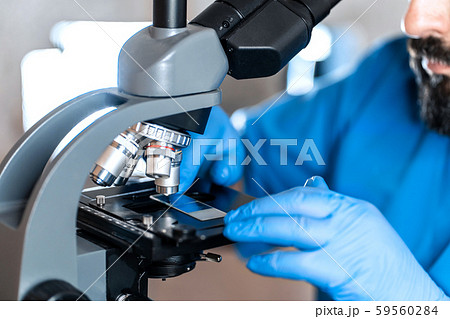 Male laboratory assistant examining biomaterial 59560284
