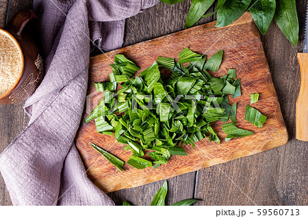 Cut up ribwort plantain leaves on a table - preparation of herbal syrup against cough 59560713