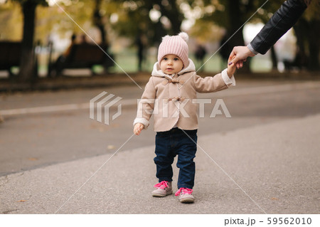 Cute little baby walking in the park with mother. Autumn 59562010