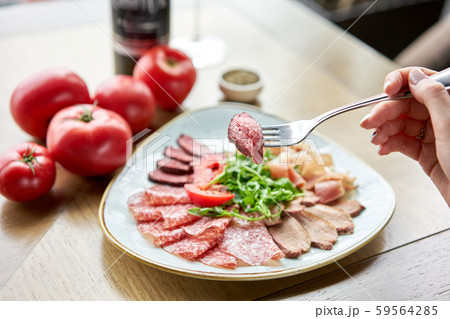 Close-up of Meat on a fork. Meat plate, delicacy and Anantipasto. Salami, roast beef, Parma ham Close-up of Meat on a fork. Meat plate, delicacy and Anantipasto. Salami, roast beef, Parma ham 59564285