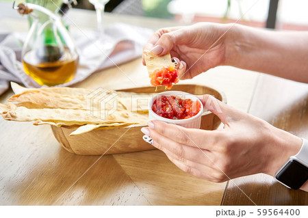 Woman eats Delicious Matzo. Served with tomato and sweet pepper chutney. Matzo, matzah, or matza is 59564400