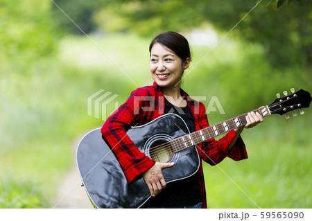 ギターを弾く女性・屋外 59565090