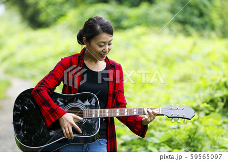 ギターを弾く女性・屋外 59565097