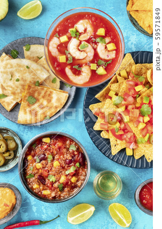 Mexican food, many dishes of the cuisine of Mexico, flat lay top-down shot from on a vibrant blue 59571849