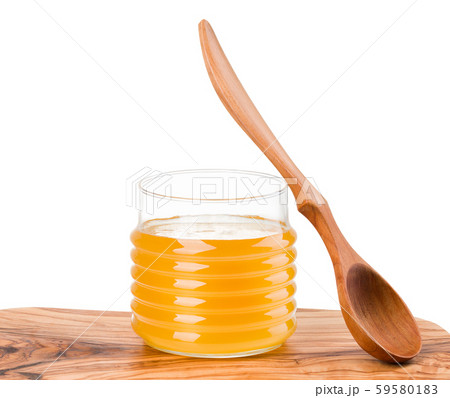 Glass jar full of honey and wooden fork on wooden plank isolated on white Glass jar full of honey and wooden fork on wooden plank isolated on white 59580183