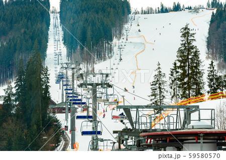 Ski slope with lift on the background of evergreen Carpathian forest, Bukovel resort, Carpathians Ski slope with lift on the background of evergreen Carpathian forest, Bukovel resort, Carpathians 59580570