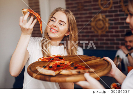 Cute friends in a cafe eatting a pizza 59584557