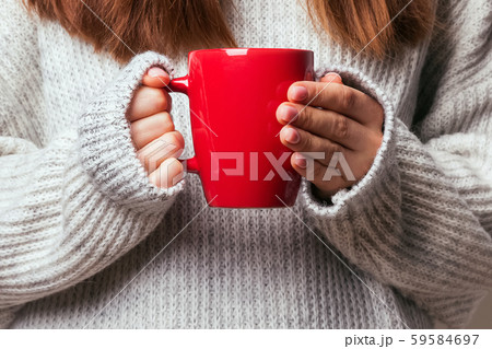 Picture of a woman's hand holding a red coffee mug 59584697