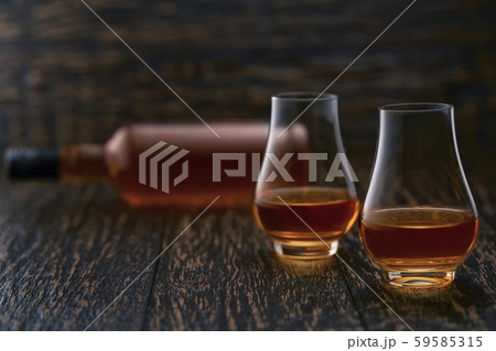 Two glasses of whiskey and silhouette full bottle 59585315