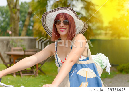 Beautiful girl leaving to the beach in bicycle Beautiful girl leaving to the beach in bicycle 59588093