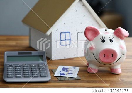 Calculator with piggy bank against home background Calculator with piggy bank against home background 59592173