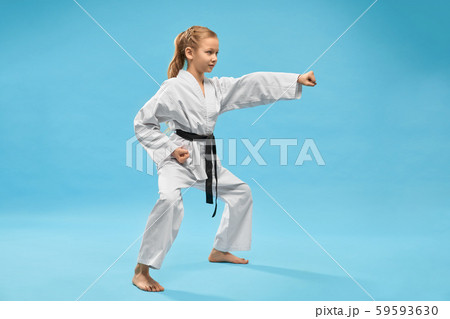 Girl in kimono standing in stance and punching with hand. 59593630