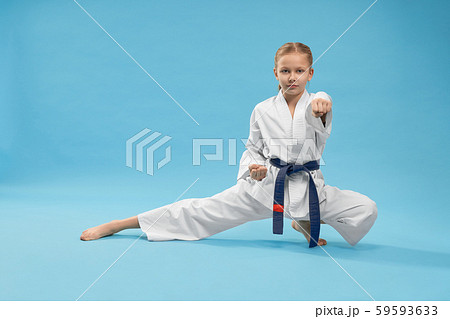 Karate girl standing in stance and training punching. 59593633