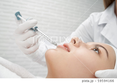 Young client receiving procedure botox of lips. Young client receiving procedure botox of lips. 59594166