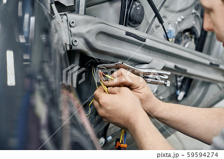 Close up of mechanics bare hands fixing electricity in car 59594274