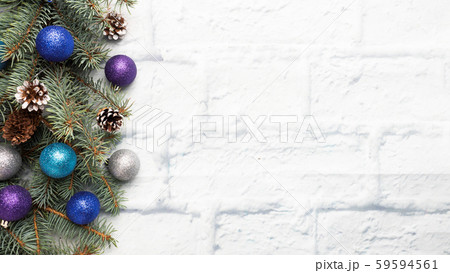 Christmas frame made of fir, Christmas tree decorations in silver and blue on a light brick background. Copy space. Flat lay. Christmas frame made of fir, Christmas tree decorations in silver and blue on a light brick background. Copy space. Flat lay. 59594561