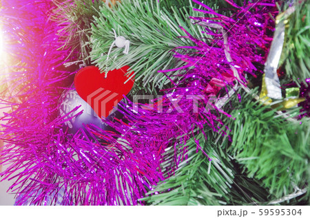 Red heart on christmas tree with tinsel, sunlight 59595304