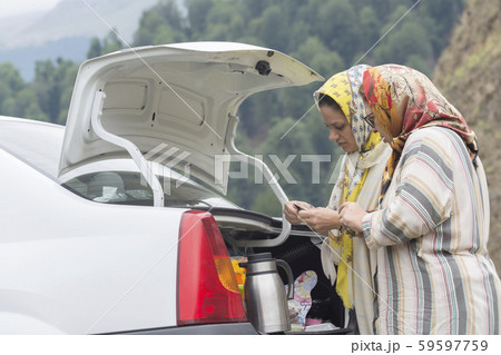 Two Muslim woman making tea at backside of car 59597759