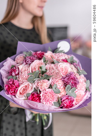 Beautiful bouquet of mixed flowers in womans hands. the work of the florist at a flower shop Beautiful bouquet of mixed flowers in womans hands. the work of the florist at a flower shop 59604486