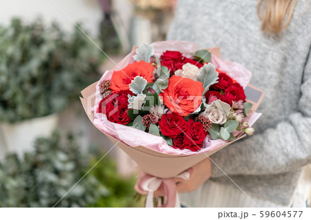 Mixed bouquet of red tones. Beautiful bunch of fresh flowers in womans hands. The work of the 59604577