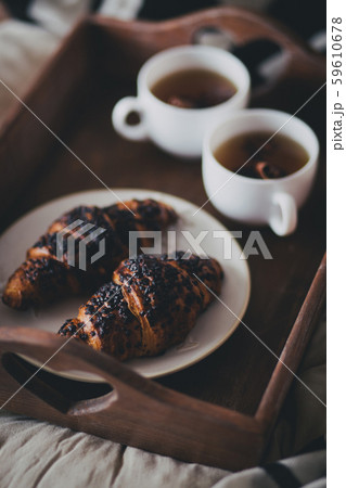 Tea and croissants on wooden tray in a cozy room Tea and croissants on wooden tray in a cozy room 59610678